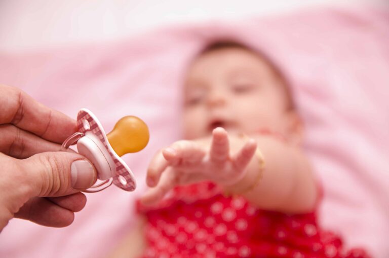 Newborn baby sleeping peacefully with a pacifier during bedtime routine